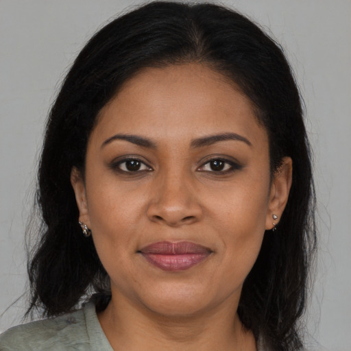 Joyful black young-adult female with long  brown hair and brown eyes