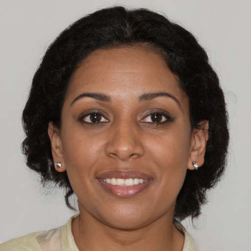 Joyful black young-adult female with medium  brown hair and brown eyes