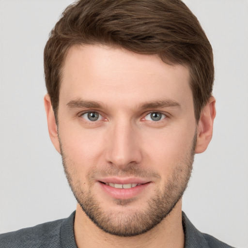 Joyful white young-adult male with short  brown hair and grey eyes