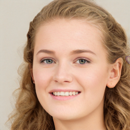 Joyful white young-adult female with long  brown hair and blue eyes