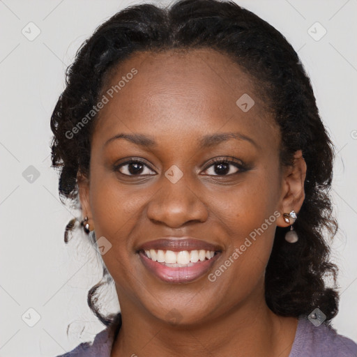 Joyful black young-adult female with long  brown hair and brown eyes