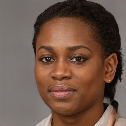 Joyful black young-adult female with short  brown hair and brown eyes
