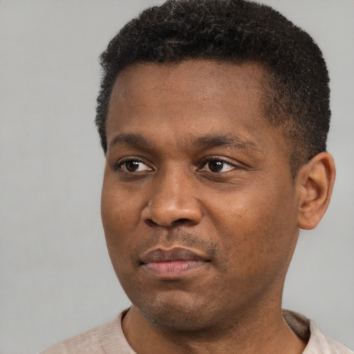 Joyful black adult male with short  black hair and brown eyes