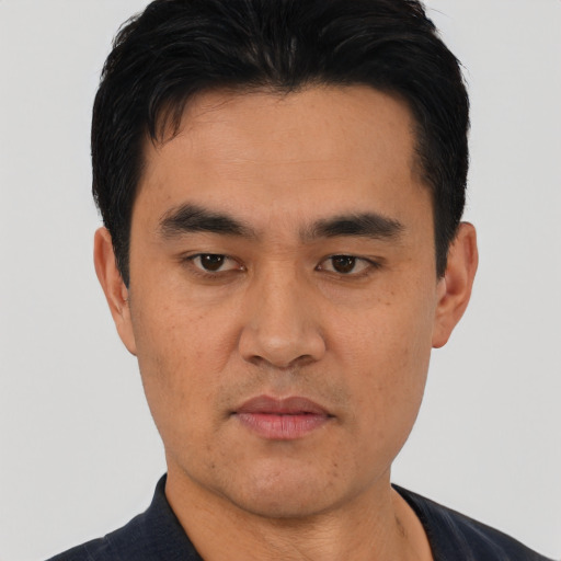 Joyful asian young-adult male with short  black hair and brown eyes