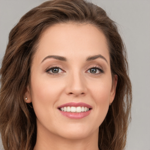 Joyful white young-adult female with long  brown hair and green eyes