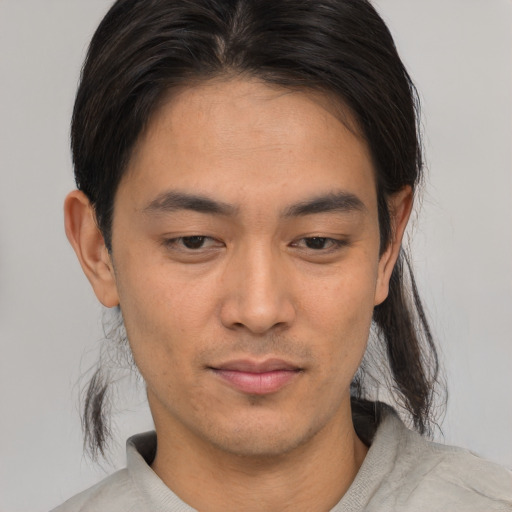 Joyful asian young-adult male with short  brown hair and brown eyes