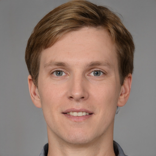 Joyful white young-adult male with short  brown hair and grey eyes