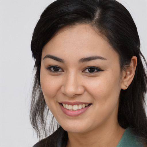 Joyful latino young-adult female with long  brown hair and brown eyes