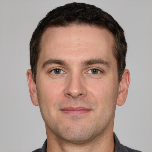 Joyful white adult male with short  brown hair and grey eyes