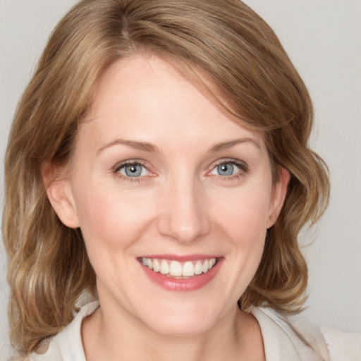 Joyful white young-adult female with medium  brown hair and blue eyes