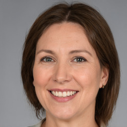 Joyful white adult female with medium  brown hair and grey eyes