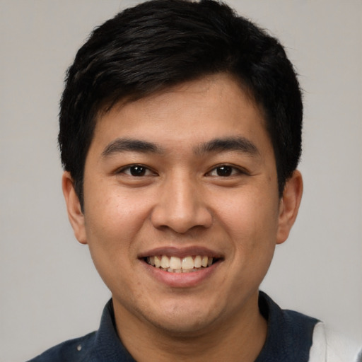 Joyful latino young-adult male with short  black hair and brown eyes