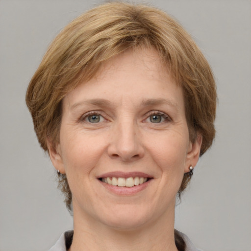 Joyful white adult female with medium  brown hair and grey eyes