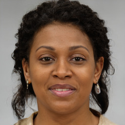 Joyful black adult female with medium  brown hair and brown eyes