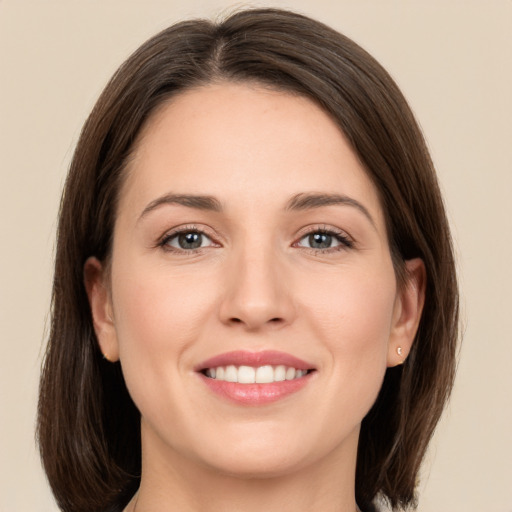 Joyful white young-adult female with long  brown hair and green eyes