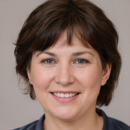 Joyful white adult female with medium  brown hair and grey eyes