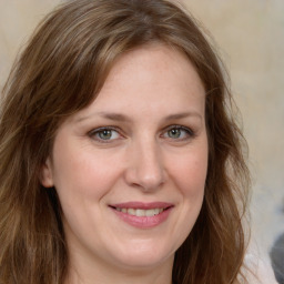 Joyful white adult female with long  brown hair and grey eyes