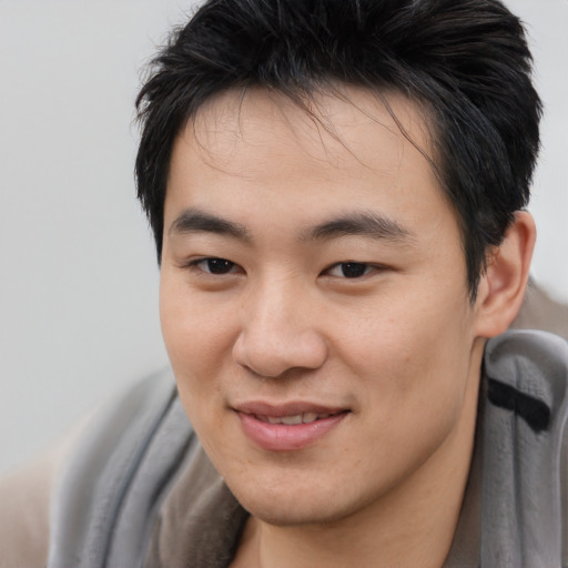 Joyful asian young-adult male with medium  brown hair and brown eyes