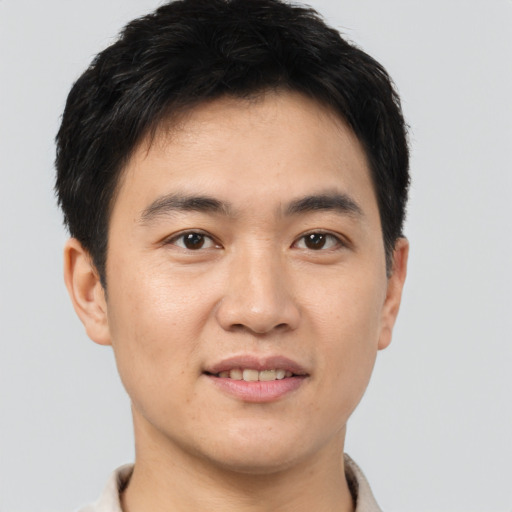 Joyful asian young-adult male with short  brown hair and brown eyes