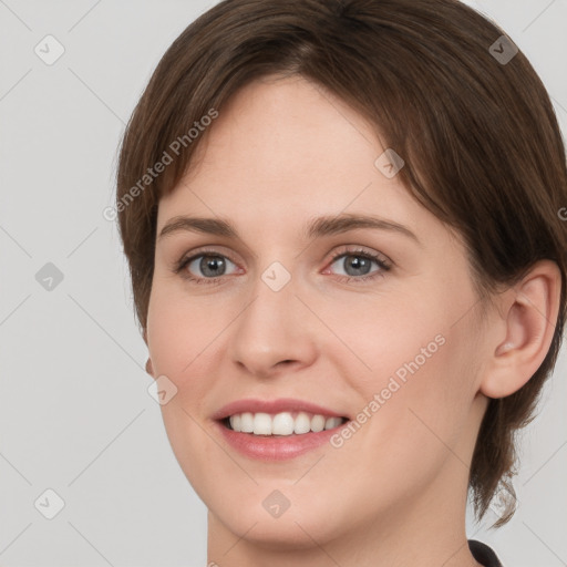 Joyful white young-adult female with short  brown hair and grey eyes