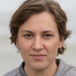 Joyful white adult female with medium  brown hair and grey eyes