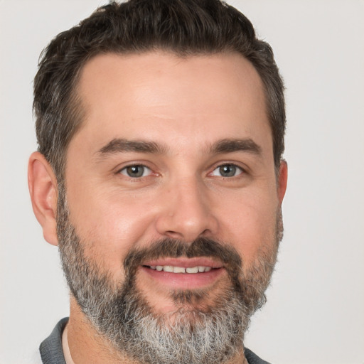 Joyful white adult male with short  brown hair and brown eyes