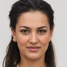 Joyful white young-adult female with long  brown hair and brown eyes