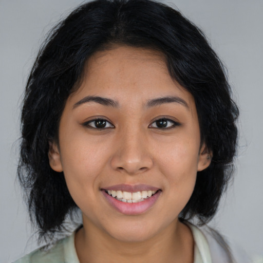 Joyful latino young-adult female with long  brown hair and brown eyes