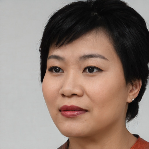 Joyful asian young-adult female with medium  black hair and brown eyes