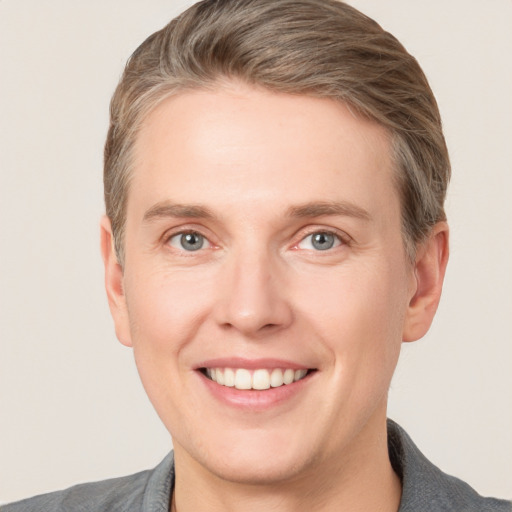 Joyful white young-adult male with short  brown hair and grey eyes