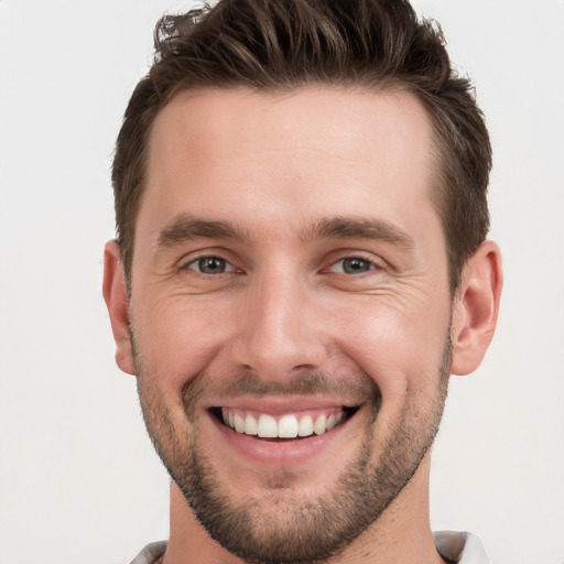 Joyful white young-adult male with short  brown hair and grey eyes