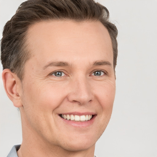 Joyful white adult male with short  brown hair and grey eyes