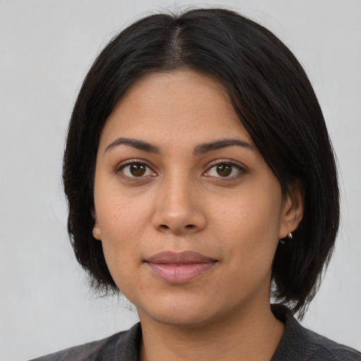 Joyful latino young-adult female with medium  black hair and brown eyes