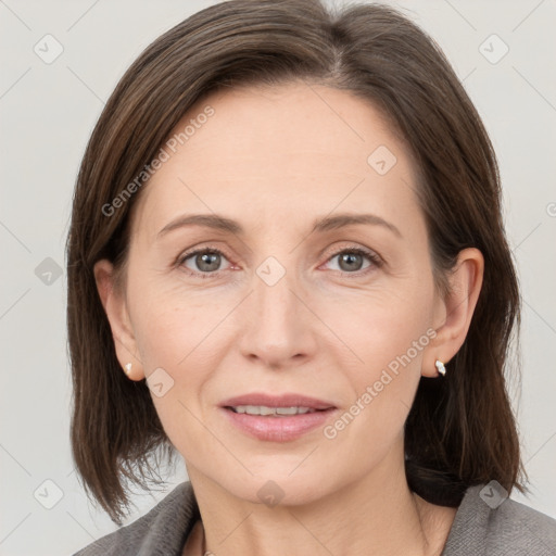 Joyful white adult female with medium  brown hair and grey eyes