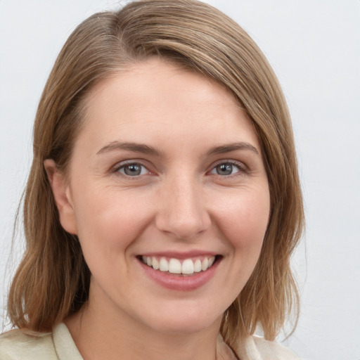 Joyful white young-adult female with medium  brown hair and grey eyes