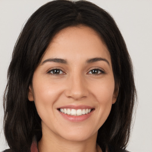 Joyful white young-adult female with long  brown hair and brown eyes