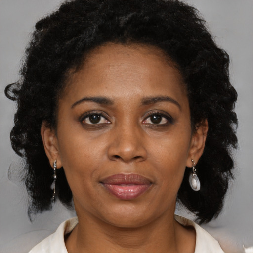 Joyful black adult female with medium  brown hair and brown eyes
