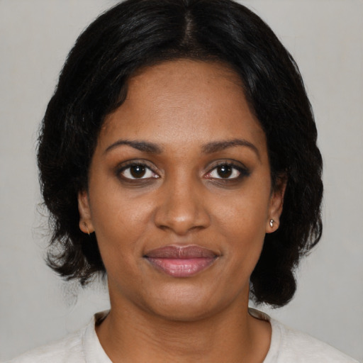 Joyful black young-adult female with medium  black hair and brown eyes