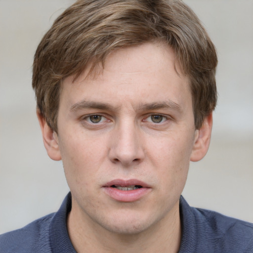 Joyful white young-adult male with short  brown hair and blue eyes