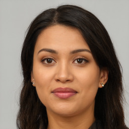 Joyful latino young-adult female with long  brown hair and brown eyes