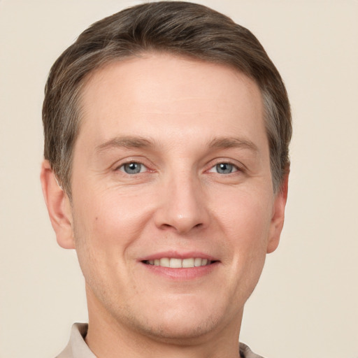 Joyful white adult male with short  brown hair and grey eyes