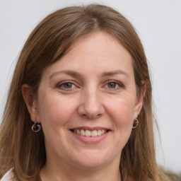 Joyful white adult female with long  brown hair and grey eyes