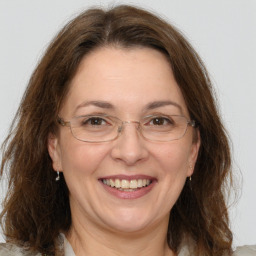 Joyful white adult female with medium  brown hair and grey eyes