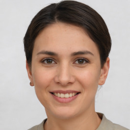 Joyful white young-adult female with short  brown hair and grey eyes