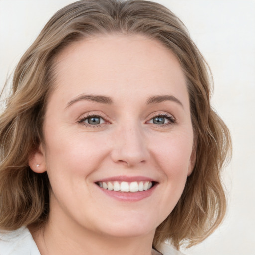 Joyful white young-adult female with medium  brown hair and blue eyes