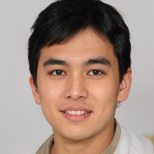 Joyful asian young-adult male with short  brown hair and brown eyes