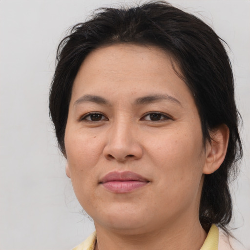 Joyful asian adult female with medium  brown hair and brown eyes
