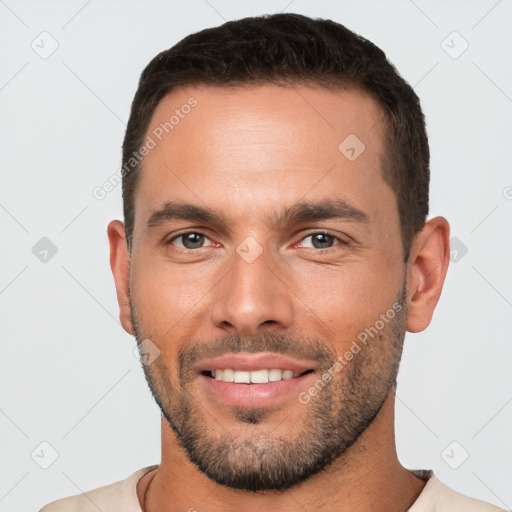 Joyful white young-adult male with short  brown hair and brown eyes