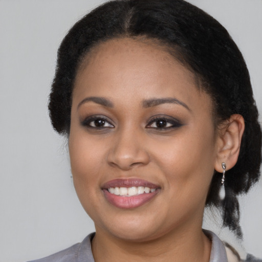 Joyful black young-adult female with medium  brown hair and brown eyes