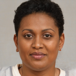 Joyful black young-adult female with short  brown hair and brown eyes